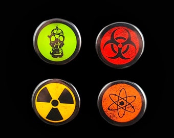 May include: Four round, black-rimmed buttons with different colored backgrounds and symbols. The first button has a green background with a black gas mask. The second button has a red background with a black biohazard symbol. The third button has a yellow background with a black radiation symbol. The fourth button has an orange background with a black atom symbol.