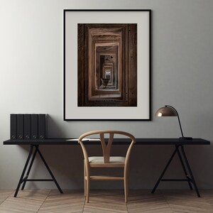 Peut inclure: Une photographie encadr&eacute;e d'un couloir avec de multiples portes, chacune menant &agrave; une autre porte, cr&eacute;ant un sentiment de profondeur et de perspective. Les portes sont en bois fonc&eacute; et ont un aspect us&eacute; et vieilli.