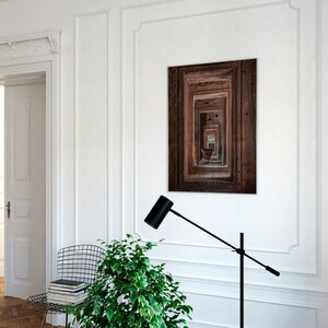 Peut inclure: Un lampadaire noir avec un long bras r&eacute;glable et un abat-jour cylindrique. La lampe est plac&eacute;e dans une pi&egrave;ce blanche avec une porte en bois et une photographie encadr&eacute;e d'une porte en bois.