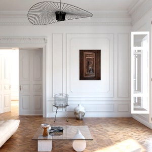 Peut inclure: Une pi&egrave;ce blanche avec un sol en bois, un canap&eacute; blanc, une table basse en verre, une chaise, un vase et une estampe encadr&eacute;e d'un couloir en bois avec un motif r&eacute;p&eacute;titif de portes.