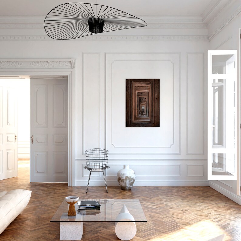 Peut inclure: Une pi&egrave;ce blanche avec un sol en bois, un canap&eacute; blanc, une table basse en verre, une chaise, un vase et une estampe encadr&eacute;e d'un couloir en bois avec un motif r&eacute;p&eacute;titif de portes.