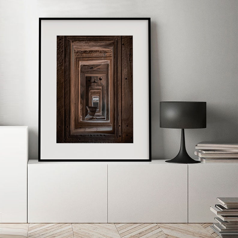 Peut inclure: Une photographie encadr&eacute;e d'un couloir avec de multiples portes, chacune avec des sculptures complexes. Les portes sont dispos&eacute;es dans une perspective qui cr&eacute;e un sentiment de profondeur et de myst&egrave;re.