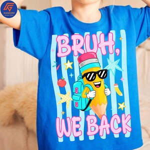May include: A bright blue t-shirt featuring a graphic of a yellow pencil character wearing black sunglasses and a light blue backpack. The text reads BRUH, WE BACK in pink letters, surrounded by light blue vertical stripes, stars, and an apple.