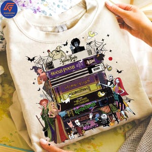 Peut inclure: Sweat-shirt beige avec une pile de cassettes VHS représentant des films d'Halloween. On y trouve des titres comme "Hocus Pocus", "Halloweentown" et "Goosebumps". Décoré de chauves-souris, de toiles d'araignées et d'autres éléments effrayants.