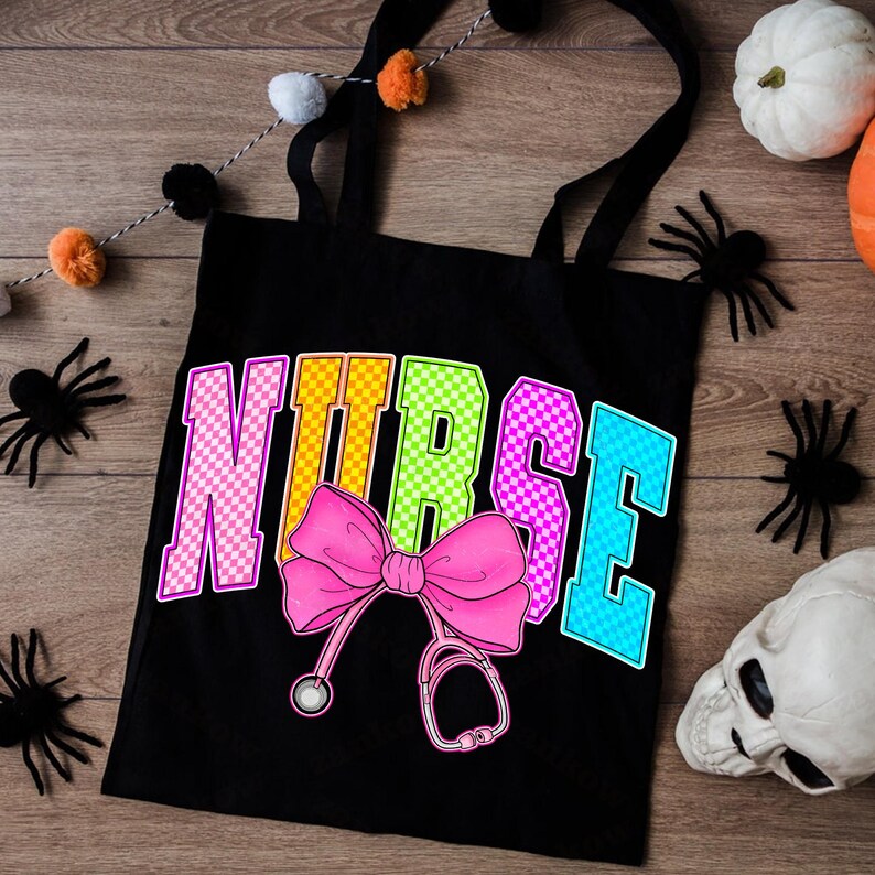 K&ouml;nnte beinhalten: Schwarze Tragetasche mit dem Wort "NURSE" in bunten karierten Buchstaben. Eine rosa Schleife und eine Stethoskop-Grafik befinden sich unter dem Wort. Der Hintergrund umfasst Halloween-Dekorationen wie Spinnen und K&uuml;rbisse.