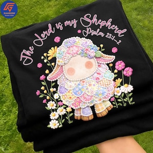 May include: Black sweatshirt featuring a colorful sheep graphic with floral accents and the text "The Lord is my Shepherd Psalm 23:1-2" in pink script. The sheep is adorned with patchwork patterns.