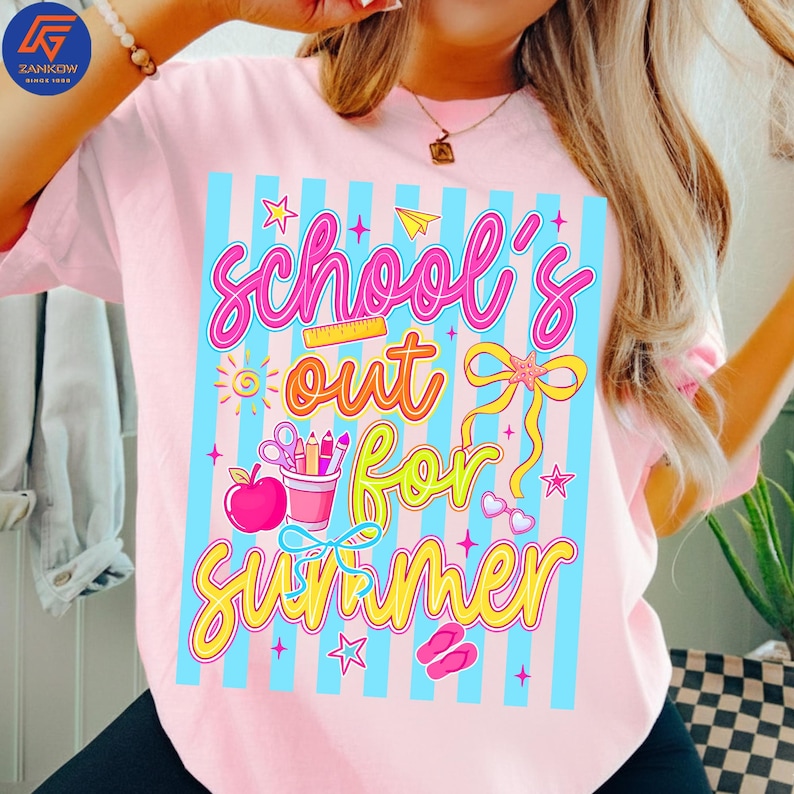 May include: Pink t-shirt with a colorful graphic that reads "School's Out For Summer." The design features a light blue striped background, stars, a sun, scissors, pencils, an apple, and other summer-themed elements. The text is in a playful, colorful font.