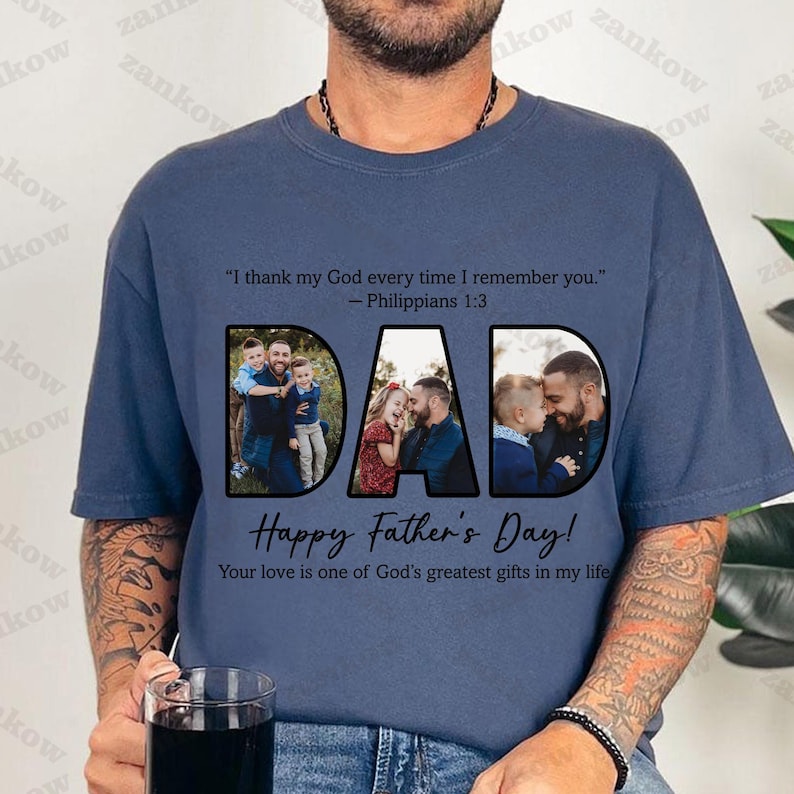May include: Navy blue t-shirt with the word "DAD" in large black letters, each letter containing a family photo. The shirt includes the text "Happy Father's Day!" and a Bible verse. A perfect gift for Father's Day.