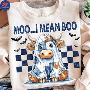 May include: A cream-coloured sweatshirt with a Halloween cow graphic. The design shows a cow in a ghost costume, with the text "MOO...I MEAN BOO" in navy blue. Black bats and a navy and white checkered pattern are also present.