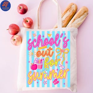 May include: Cream-colored tote bag with blue vertical stripes and the words "School's Out For Summer" in pink, orange, and yellow. The bag contains two baguettes and is surrounded by red apples.