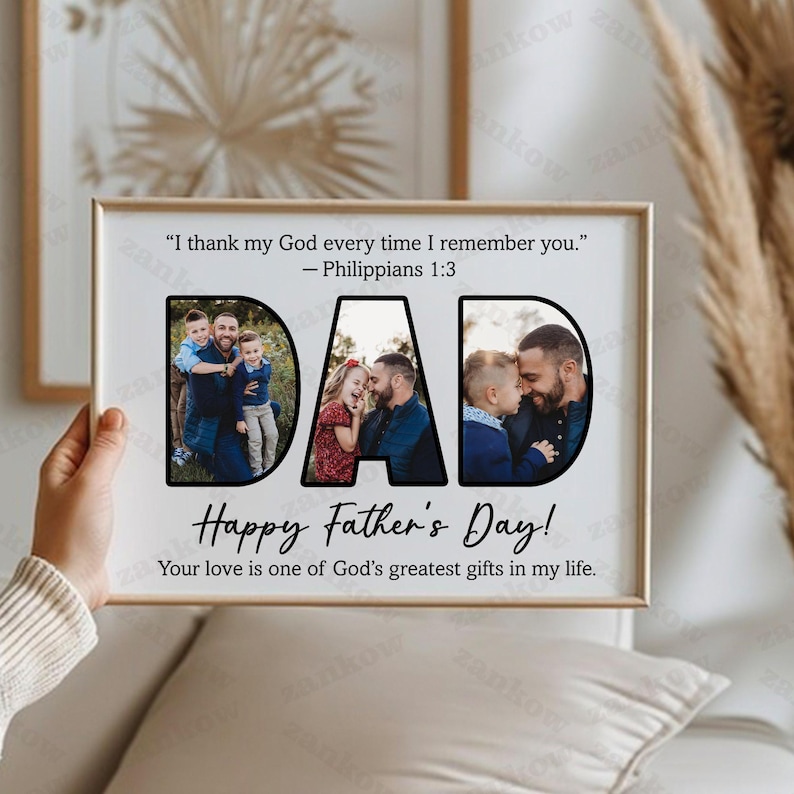 May include: A framed photo print with the word "DAD" in large black letters, each letter containing a family photo. The phrase "Happy Father's Day!" is below, with additional text. The frame is held by a person.