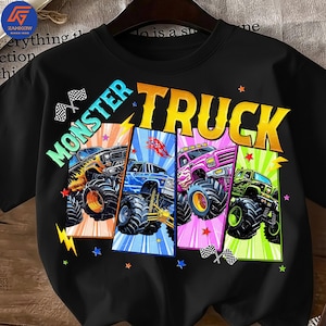 May include: Black t-shirt featuring the words "MONSTER TRUCK" in large, colorful letters. The shirt displays four monster trucks in different colors: yellow, blue, pink, and green. Each truck is set against a vibrant background with stars and checkered flags.