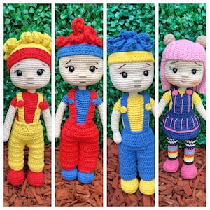 Peut inclure: Quatre poupées en crochet avec des tenues et des cheveux de différentes couleurs. Les poupées portent des salopettes et ont des cheveux de différentes couleurs. Les poupées sont debout sur une surface brune.