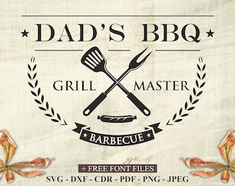 May include: A black and white sign with the text "DAD'S BBQ" and "GRILL MASTER". The design includes crossed grilling tools, a sausage, and a banner that says "BARBECUE". The sign is on a light wood-grain background.