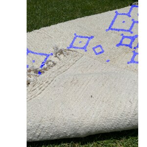 Alfombra Beni Ourain, de lana marroquí anudada a mano, color marfil con formas geométricas azules. imagen 6