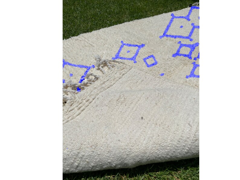 Alfombra Beni Ourain, de lana marroquí anudada a mano, color marfil con formas geométricas azules. imagen 6
