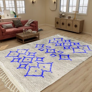 Alfombra Beni Ourain, de lana marroquí anudada a mano, color marfil con formas geométricas azules. imagen 1