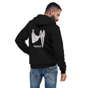 May include: Black hooded sweatshirt with a graphic design on the back featuring a wedding dress and a suit. The text "CODE FASHIONABLY" is printed below the design. The sweatshirt is worn by a person.