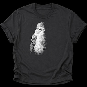 Könnte beinhalten: Ein anthrazitfarbenes T-Shirt mit kurzen Ärmeln und einer detaillierten weißen Strichzeichnung eines kleinen Vogels auf der Brust. Der Vogel ist mit feinen, skizzenartigen Strichen dargestellt, die Kopf, Auge und das gefiederte Brustgefieder zeigen.