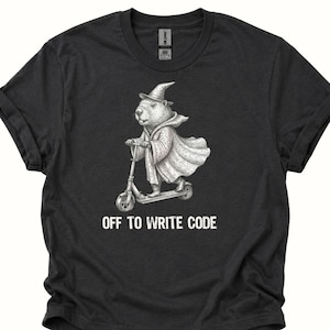 Könnte beinhalten: Dunkelgraues T-Shirt mit einer detaillierten Illustration eines Murmeltiers mit Zaubererhut und Umhang, das einen Roller fährt. Der Text "OFF TO WRITE CODE" ist darunter in Weiß gedruckt.