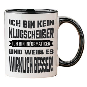 Könnte beinhalten: Weißer Keramikbecher mit schwarzem Rand und Henkel. Der Becher zeigt einen schwarzen Text auf Deutsch: "ICH BIN KEIN KLUGSCHEISSER, ICH BIN INFORMATIKER UND WEISS ES WIRKLICH BESSER!"