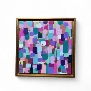 Peut inclure: Peinture abstraite avec un cadre dor&eacute;. L'&oelig;uvre pr&eacute;sente un arrangement color&eacute; de formes rectangulaires dans des tons de rose, de violet, de sarcelle et d'or. La peinture est de format carr&eacute; et est expos&eacute;e sur un fond blanc.