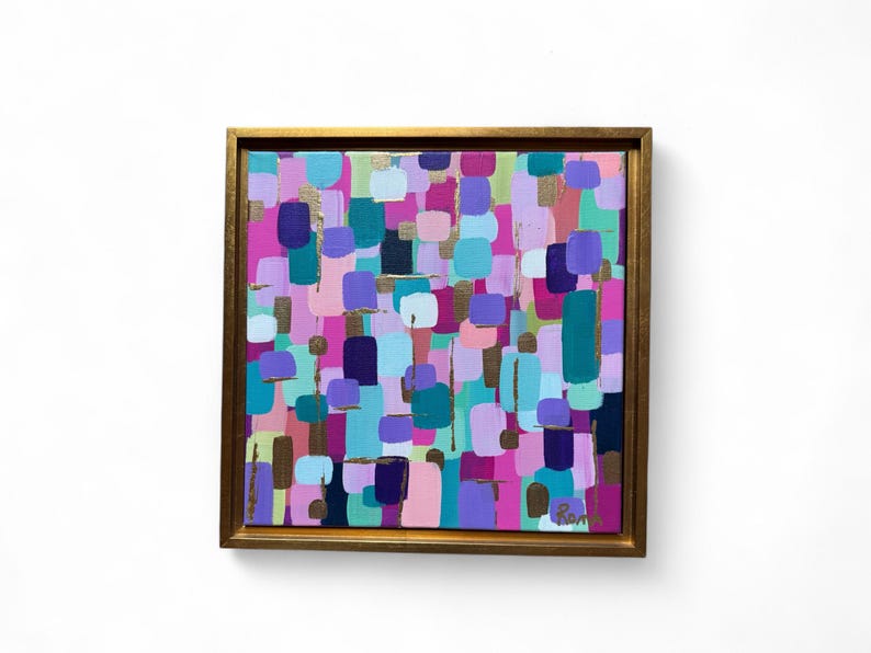 Peut inclure: Peinture abstraite avec un cadre dor&eacute;. L'&oelig;uvre pr&eacute;sente un arrangement color&eacute; de formes rectangulaires dans des tons de rose, de violet, de sarcelle et d'or. La peinture est de format carr&eacute; et est expos&eacute;e sur un fond blanc.
