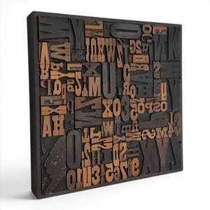 May include: A square, wooden block art piece featuring an assortment of vintage letterpress printing blocks. The blocks are a mix of dark brown and natural wood tones, arranged in a seemingly random pattern within a black frame.