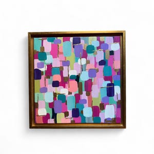 Peut inclure: Peinture abstraite carr&eacute;e avec un cadre dor&eacute;. L'&oelig;uvre pr&eacute;sente un arrangement color&eacute; de formes rectangulaires dans des tons de rose, de violet, de sarcelle et d'or. La peinture est mont&eacute;e sur un fond blanc.