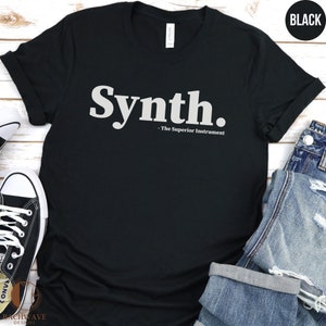 May include: Black t-shirt with white text that reads "Synth. - The Superior Instrument"