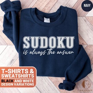May include: A navy blue sweatshirt with the text "SUDOKU is always the answer" in white. The sweatshirt is available in black and white design variations.