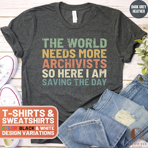 May include: Dark grey heather t-shirt with a vintage-style graphic that reads "The world needs more archivists so here I am saving the day".