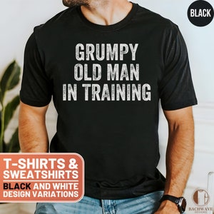May include: A black t-shirt with white text that reads "Grumpy Old Man in Training".