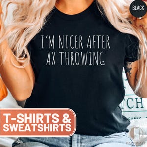 May include: Black t-shirt with white text that reads "I'm nicer after ax throwing".
