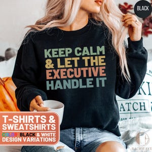 May include: Black sweatshirt with the text "Keep Calm & Let The Executive Handle It" in a vintage style font. The text is in shades of yellow, orange, green, and blue.