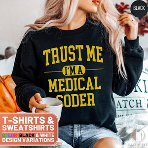 May include: Black sweatshirt with yellow text that reads "Trust Me I'm a Medical Coder". The sweatshirt is available in black and white.
