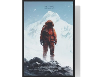 Könnte beinhalten: Ein Filmplakat für den Film "The Thing" mit einer einsamen Figur in einer rot-orangenen Winterjacke, die auf einem schneebedeckten Berggipfel steht. Der Text "The Thing" befindet sich oben auf dem Plakat, darunter die Worte "A John Carpenter Film". Das Plakat enthält auch den Text "Universal Pictures Presents" und die Namen der Schauspieler und der Crew.