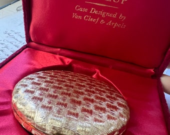 1960s Makeup Compact Revlon x Van Cleef & Arpels. Pristine original box. Gold tone basket weave with Sapphire-like stone button clasp.