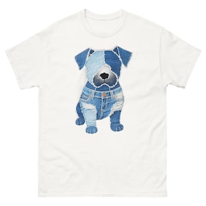 Puede incluir: Camiseta blanca con una ilustración de perro de mezclilla azul. El perro lleva vaqueros y tiene un diseño de patchwork de mezclilla. Esta camiseta gráfica es una prenda única y elegante.