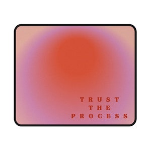 May include: A pink and orange gradient mousepad with the text "TRUST THE PROCESS" in red.