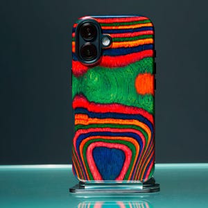 Op de afbeelding: Een kleurrijke telefoonhoes met een levendig, abstract houtnerfdesign. De hoes heeft een mix van rode, groene, oranje en blauwe tinten, waardoor een uniek en opvallend patroon ontstaat. De telefoonhoes heeft een zwart cameramodule.