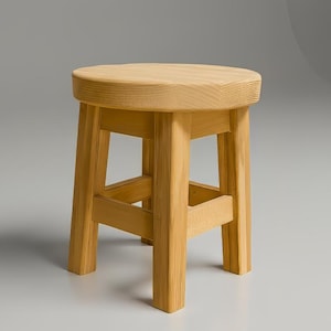 Può includere: Un piccolo sgabello rotondo in legno con finitura naturale. Lo sgabello ha un sedile circolare e quattro gambe quadrate collegate da supporti orizzontali. La venatura del legno è visibile e lo sgabello appare robusto e di design semplice.