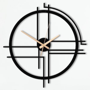 以下が含まれることがあります： 円形のフレームと交差する線を持つ、黒と金の幾何学的な壁掛け時計。時計の針は金色です。