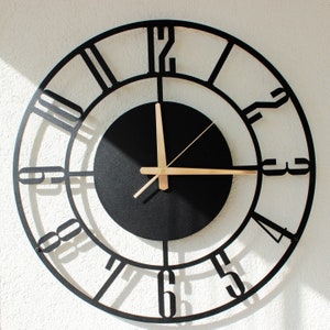 Black metal wall clock with gold pointer numbers