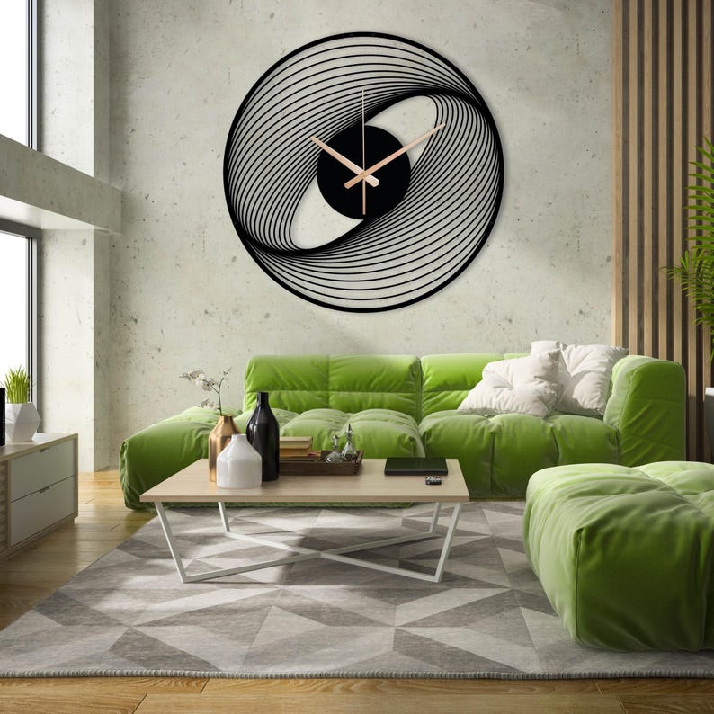 May include: A large, modern wall clock with a black, abstract design. The clock face features a swirling pattern of lines and light brown clock hands. The clock is mounted on a textured, light-colored wall in a living room setting.