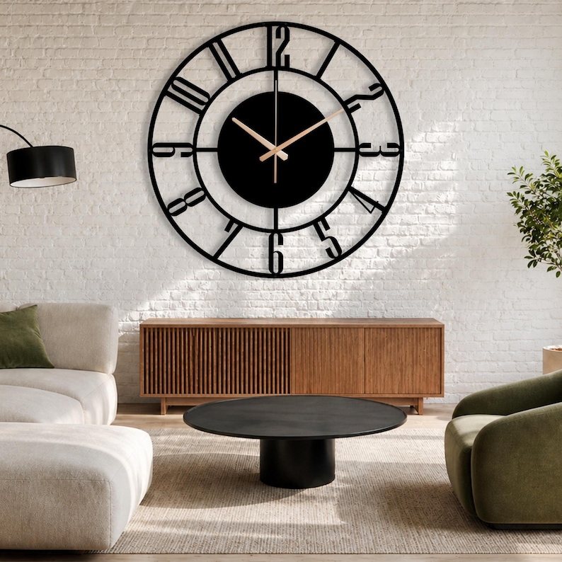 Large black Roman numeral metal wall clock with gold hands displayed on a white brick living room wall above a wooden console.