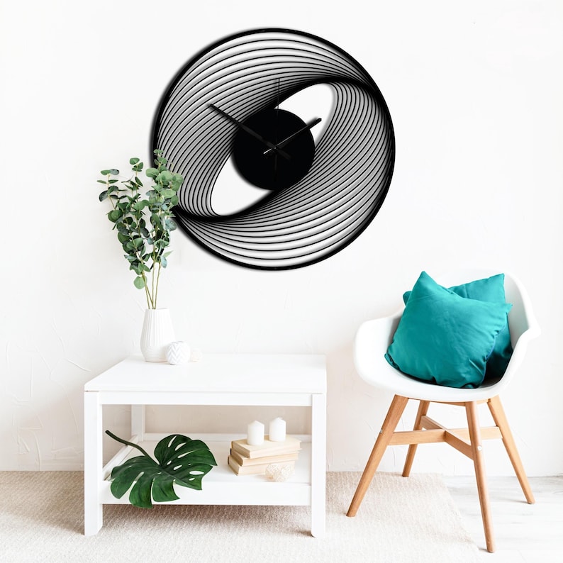 May include: A modern black and white wall clock with a unique, swirling design. The clock face is black, and the hands are black. The clock is mounted on a white wall. The clock's diameter is approximately 20 inches.