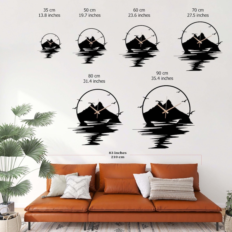 May include: Six circular wall clocks featuring a black mountain silhouette with birds and water reflection. Sizes range from 13.8 inches to 35.4 inches in diameter, displayed above a brown leather sofa measuring 83 inches in total width.