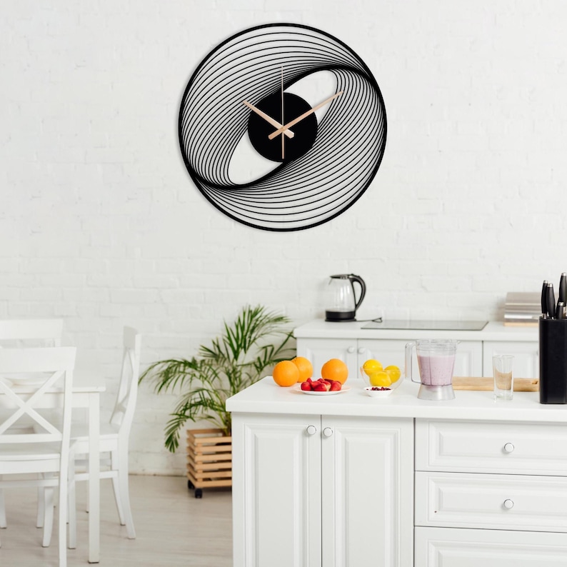 May include: A modern, black and white wall clock with a unique, swirling design. The clock face features a black center with light-colored hands. The clock is mounted on a white brick wall.