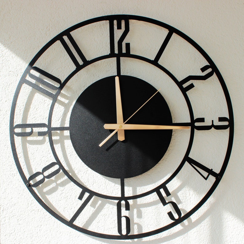 Black metal wall clock with gold pointer numbers